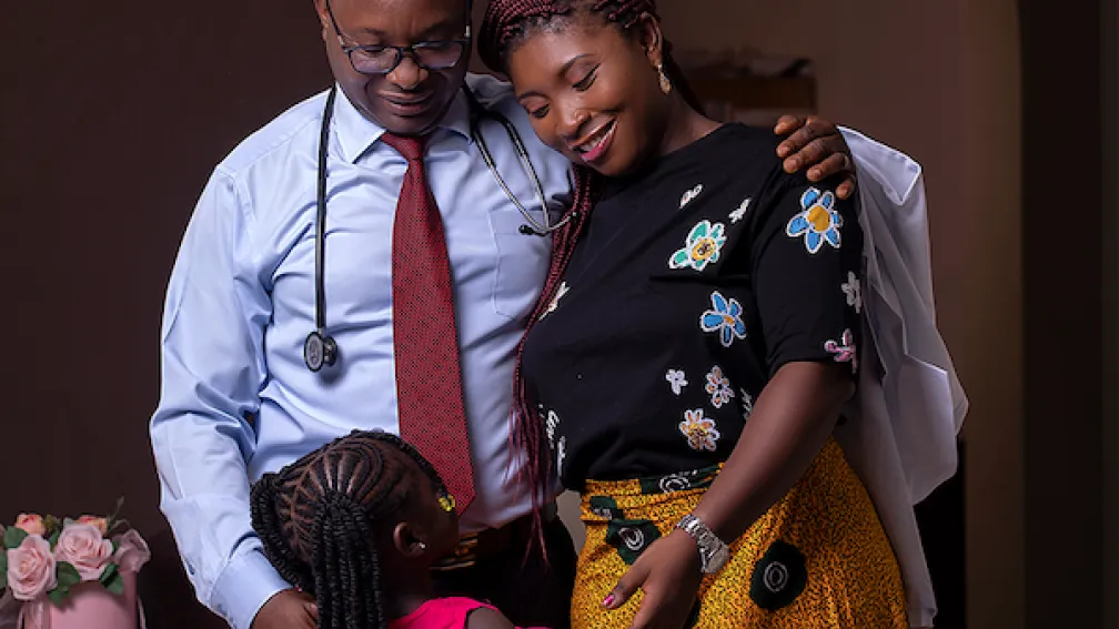 Family of three with parents smiling at daughter